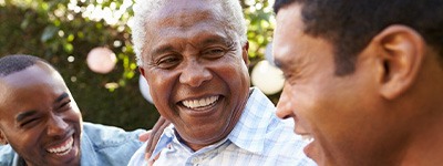 Three men outside laughing together