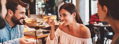 Group of friends smiling while eating at restaurant