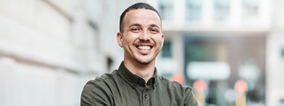 a smiling man with his arms crossed