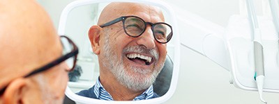 Man smiling at reflection in mirror