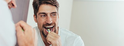 a dental implant patient brushing his teeth