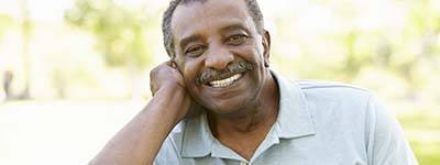 man in a green polo shirt sitting outside