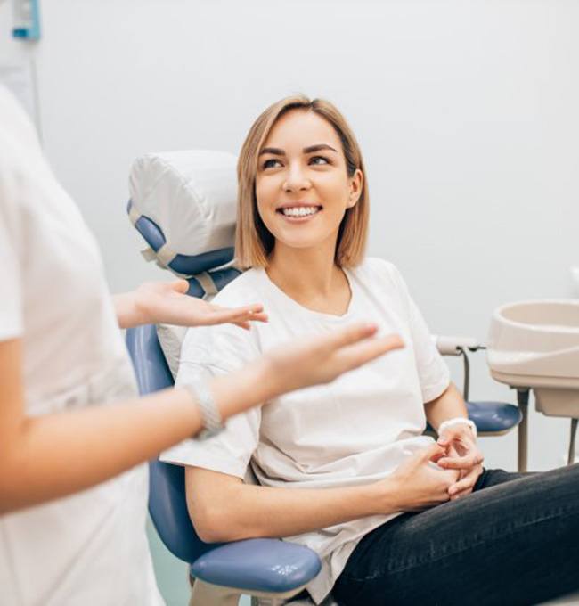 a dental patient smiling while visiting her dentist
