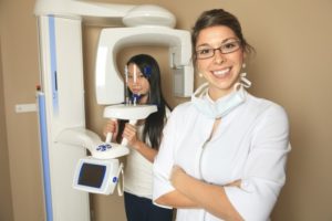 a dental assistant helping a patient with the CBCT machine