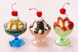 Three ice cream sundaes in a colorful glasses