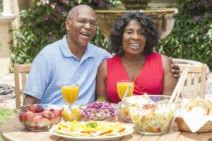 couple with dental implants in Chaska eating various summer foods 