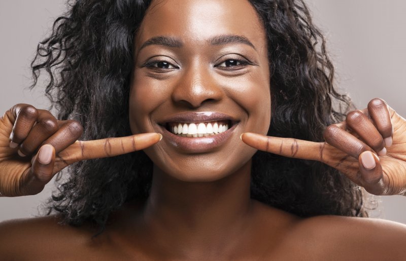 young woman pointing to white smile