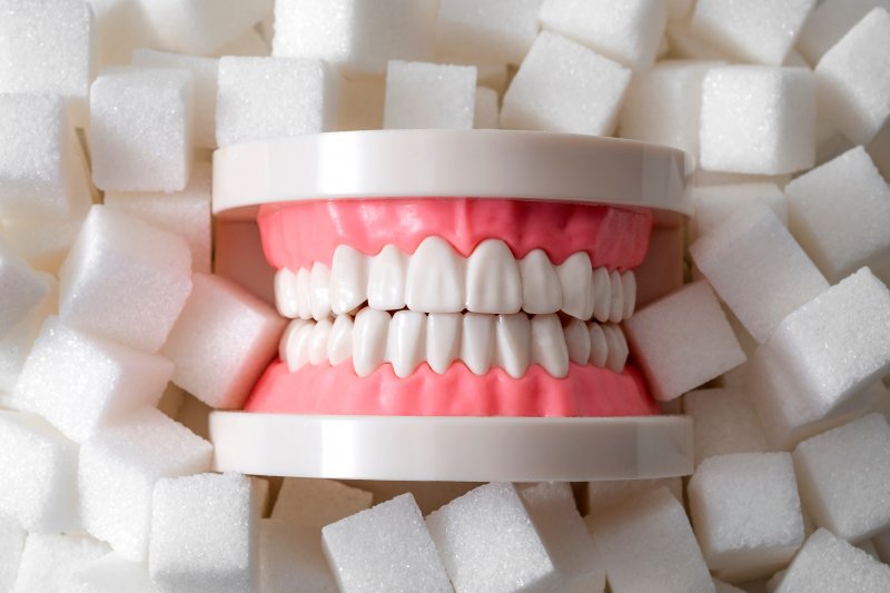 Model of teeth against background of sugar cubes