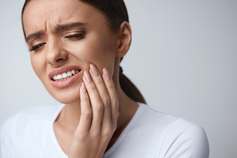 person having dental emergency holding cheek