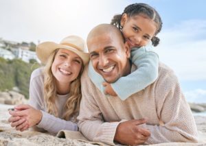 a family with healthy smiles at the beach for their summer vacation